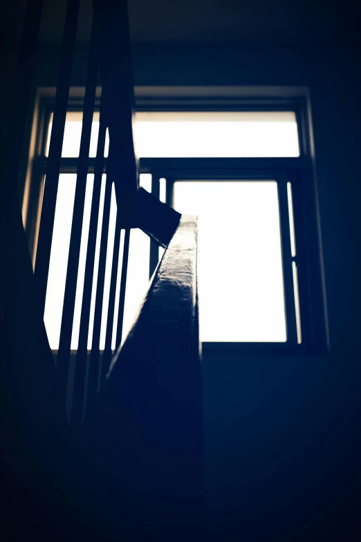 a staircase leading up to a window in a dark room, an album cover, inspired by Elsa Bleda, unsplash, conceptual art, holding a crowbar, silhouette, full daylight, cold blue light from the window