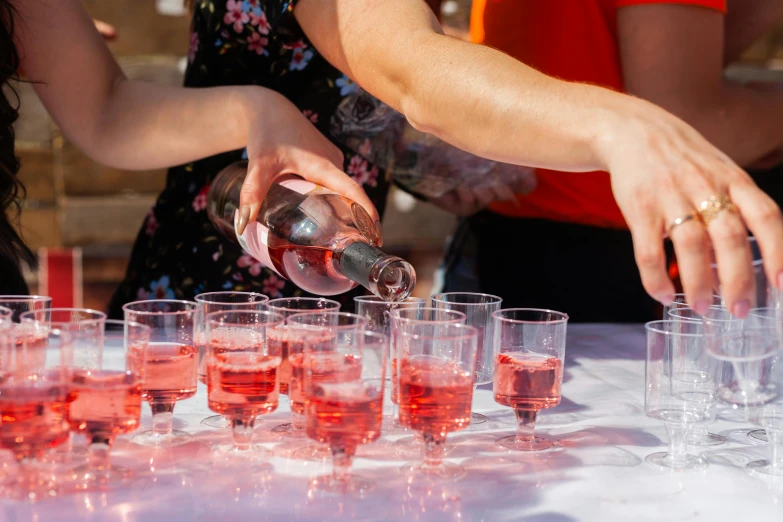 several glasses of wine are lined up and being served