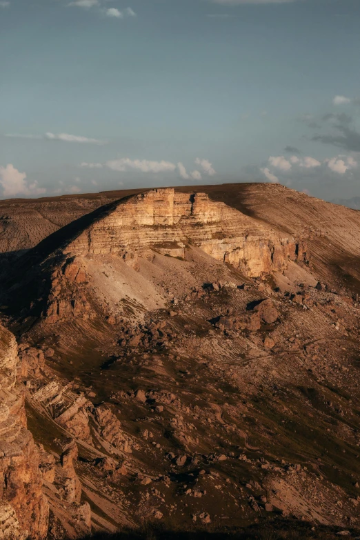 a large steep cliff and trees on top