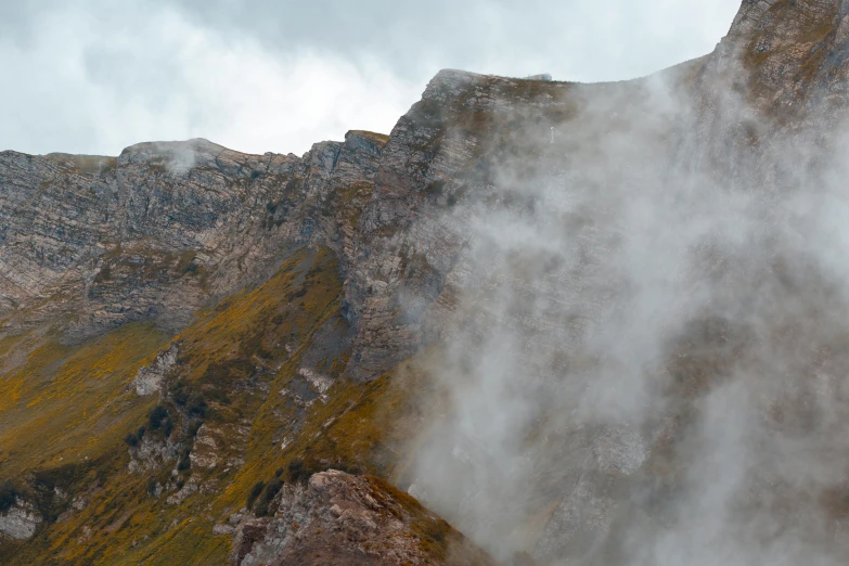 the view from below a mountain with steam coming out