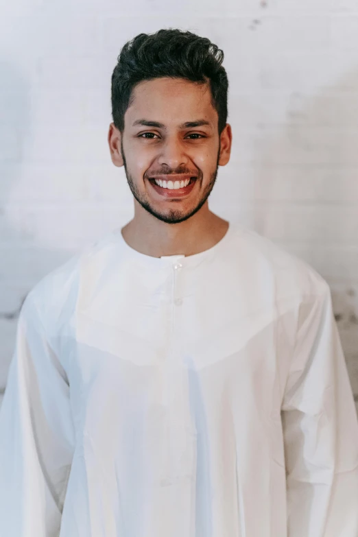 a smiling man with black hair and a beard