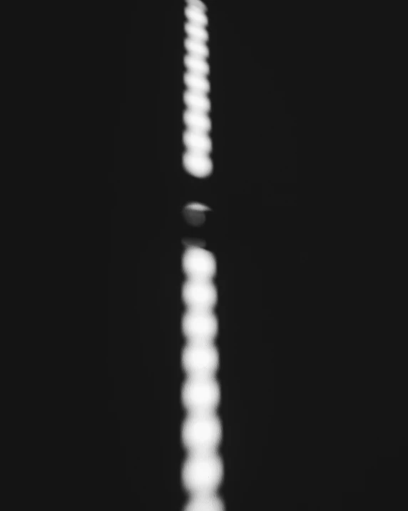 a black and white photo of the eiffel tower, a black and white photo, inspired by Ryoji Ikeda, light and space, light circles, very blurry, limbo game, minimalist lighting