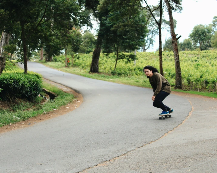 a man riding a skateboard down a curvy road, sarah cliff, carving, feature, low quality photo