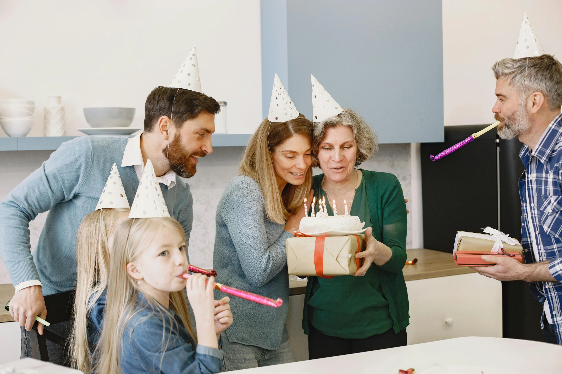 a group of people standing around a birthday cake, a colorized photo, pexels contest winner, party hats, gifts, profile image, families playing