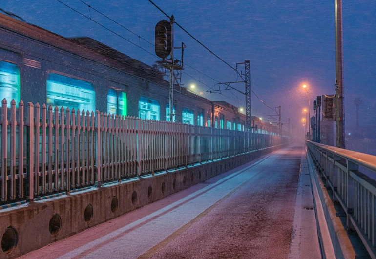 a large long train on a steel track, by Adam Marczyński, snowfall at night, foggy at dawn, snowy italian road, train station in summer