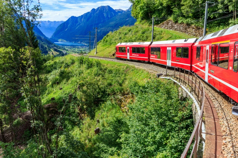 a red train traveling through a lush green valley, by Werner Andermatt, pexels contest winner, art nouveau, conde nast traveler photo, 🚿🗝📝