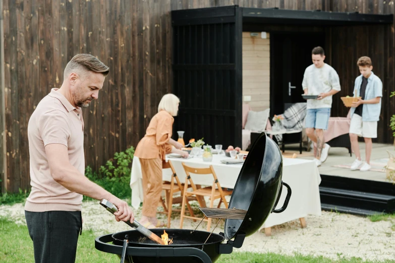 a man grilling a hot dog on a grill, by Sam Black, pexels contest winner, hammershøi, chris evans peeks out of an egg, family dinner, exterior shot