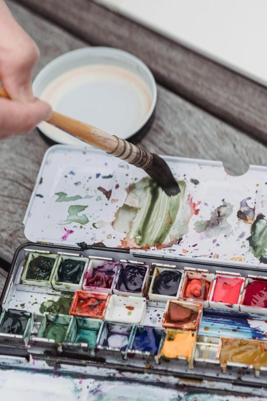 a palette and the other paints in front of the tray