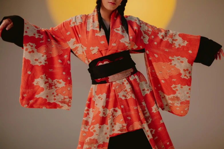 the young asian woman is wearing an orange kimono