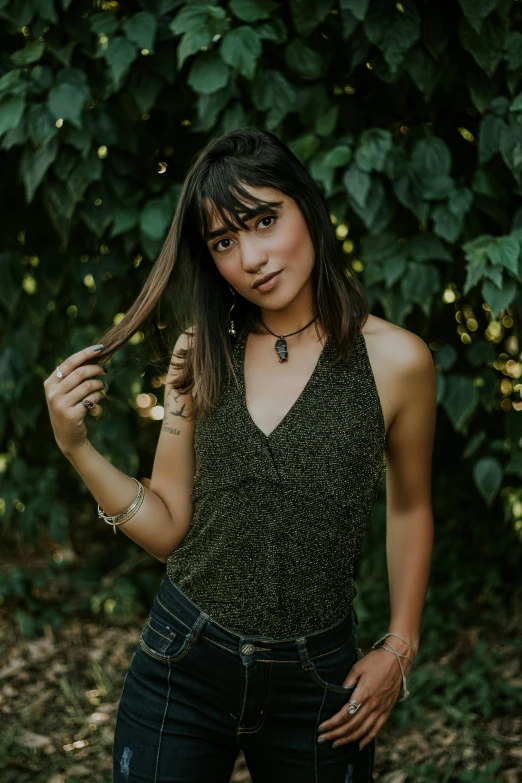 a woman standing next to a lush green forest