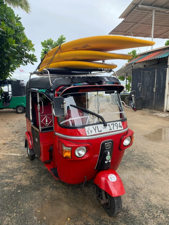 a red tuk - tuk with a surfboard on top, photograph taken in 2 0 2 0, avatar image