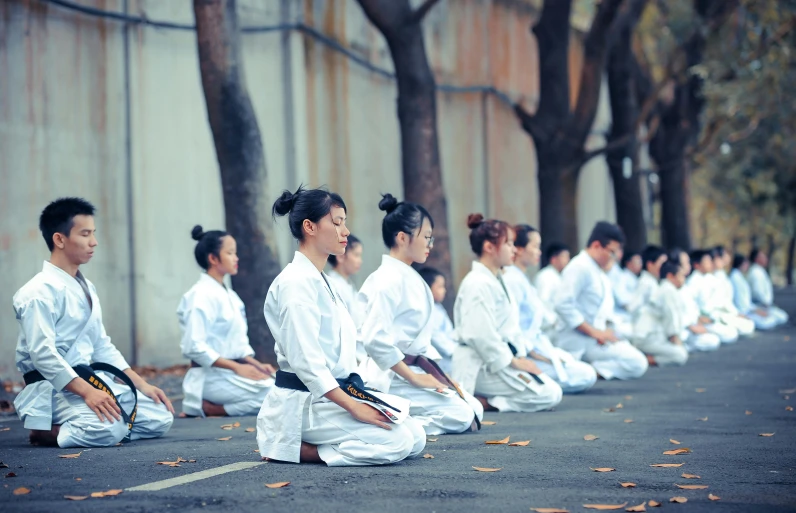 a group of people that are sitting in the street, inspired by Baiōken Eishun, unsplash, gutai group, karate outfit, avatar image, bo xun ling, practice