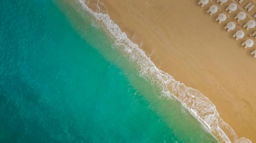 an aerial view of a beach with umbrellas and chairs, by Robbie Trevino, hurufiyya, turquoise gradient, nature photo