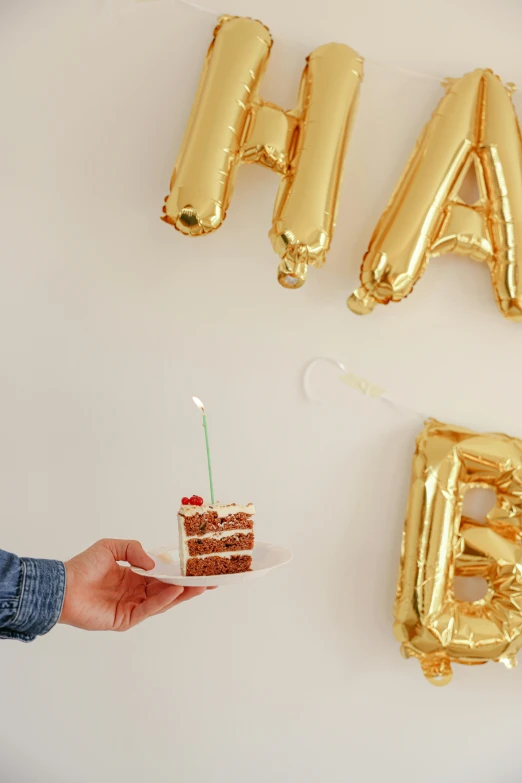 a person holding a piece of cake in front of balloons that say happy b day, happening, floating metallic objects, gold dappled light, full product shot, multiple stories