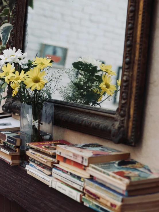 a table topped with books and flowers next to a mirror, 2019 trending photo, candid portrait photo, gif, 🌸 🌼 💮
