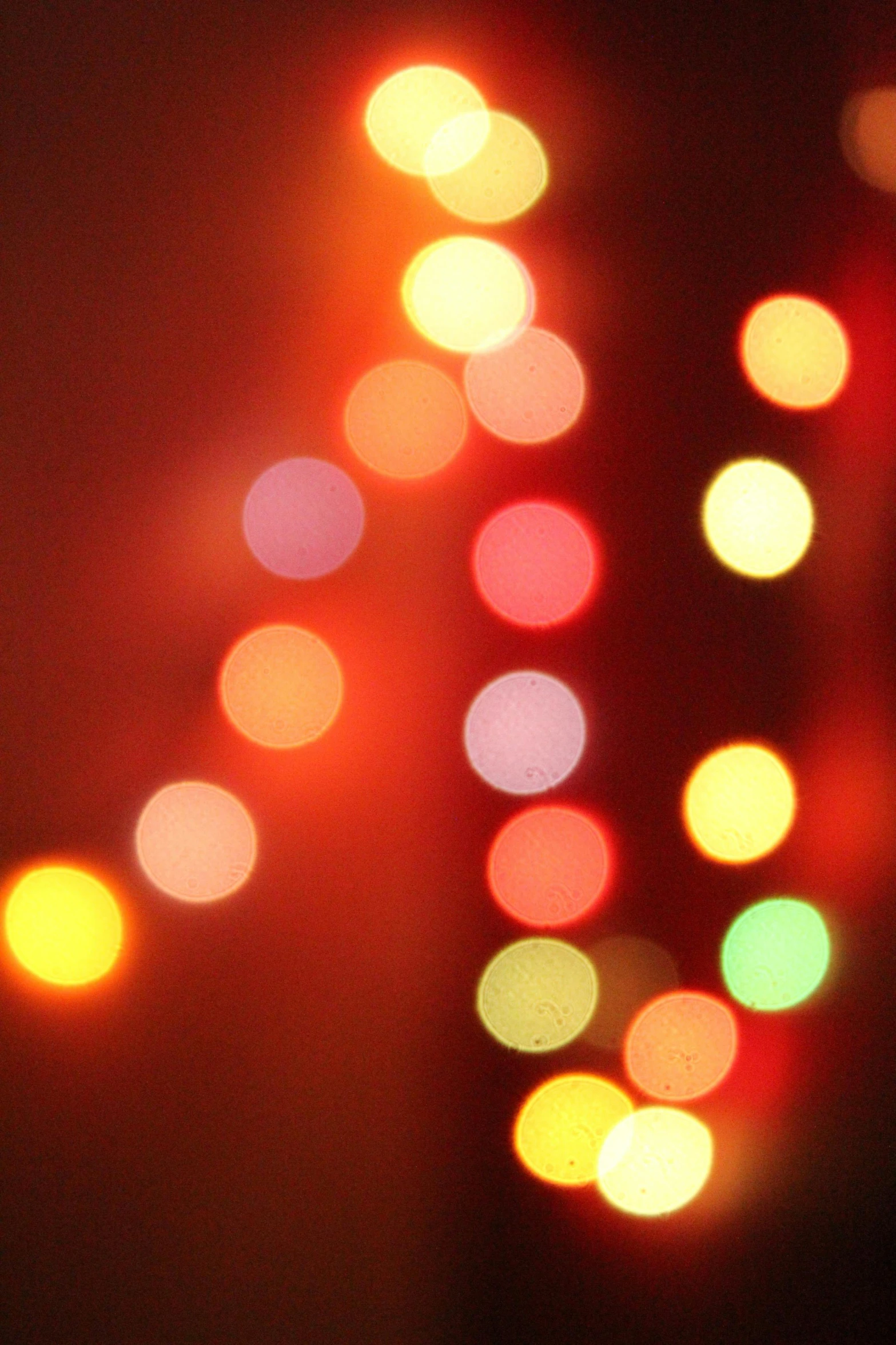 a blurry photo of christmas lights in the dark, by David Donaldson, pexels, lyrical abstraction, light red and orange mood, varying dots, hazy, music video