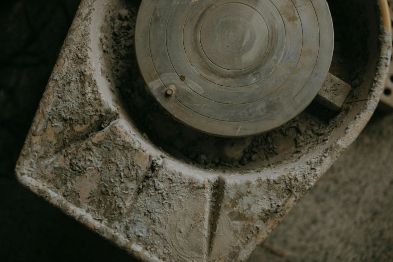 a dirty toilet sitting on top of a cement floor, by Attila Meszlenyi, unsplash contest winner, concrete art, made from mechanical parts, on textured disc base, dials, still from film