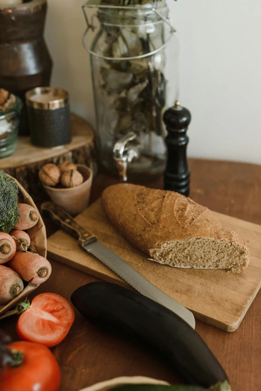 a wooden table topped with vegetables and bread, a still life, unsplash, detailed product image, angled shot, half image, cottagecore