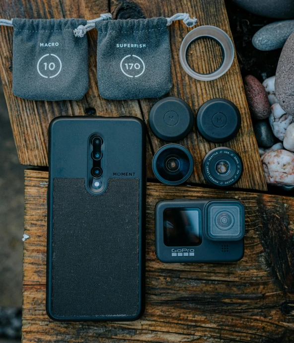 a cell phone sitting on top of a wooden table, a picture, by Alejandro Obregón, pexels contest winner, small vials and pouches on belt, gopro photo, modern minimalist f 2 0 clean, a group photo of a seal