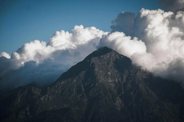 the mountain tops covered in cloud covered sky