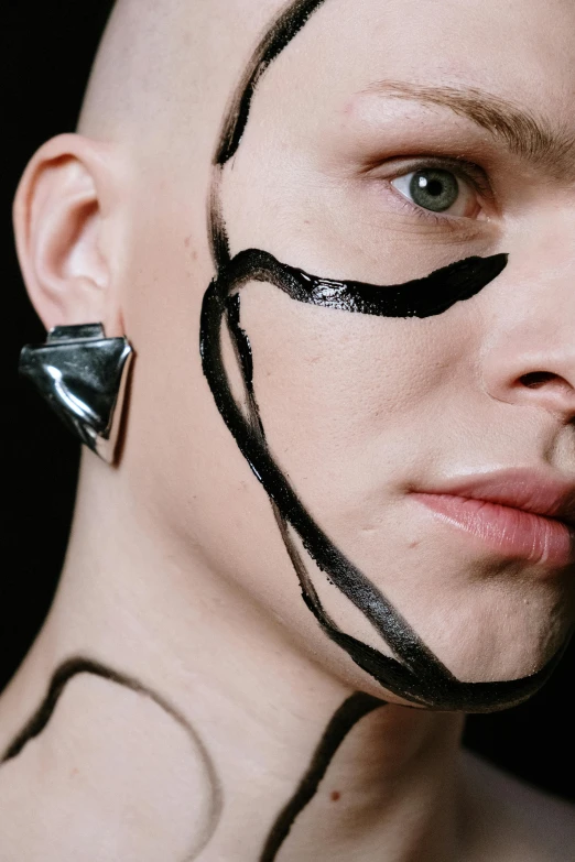 a close up of a person with black paint on their face, an album cover, trending on pexels, genderless, julian ope, black marker, angular jawline