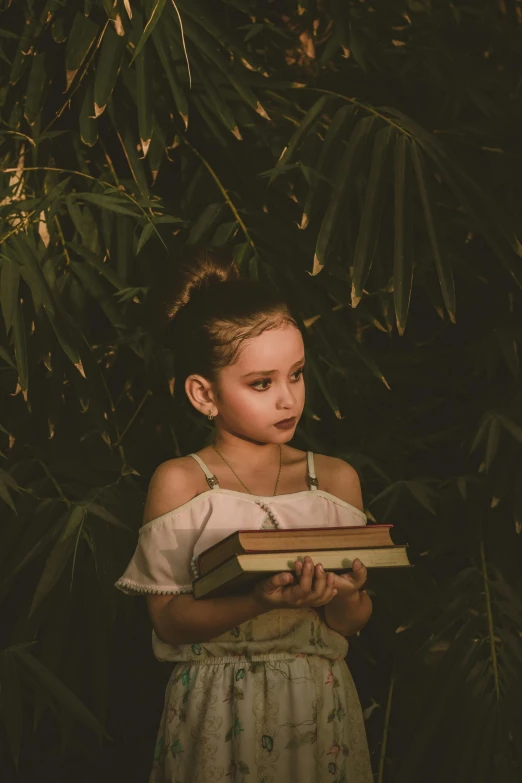 a little girl holding a book in her hands, pexels contest winner, australian tonalism, jungle, avatar image, stacked image, handsome girl