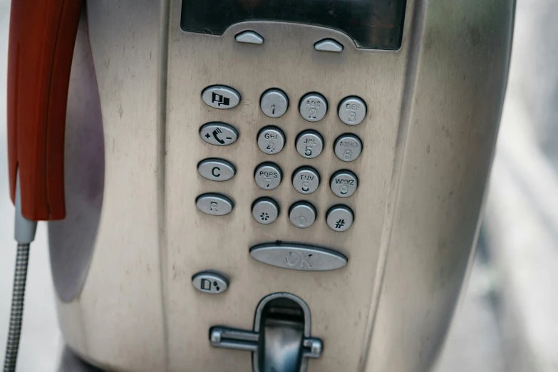 a silver pay phone sitting on top of a sidewalk, by Elsa Bleda, ship control panel close-up, 1 6 9 5, fan favorite, brown