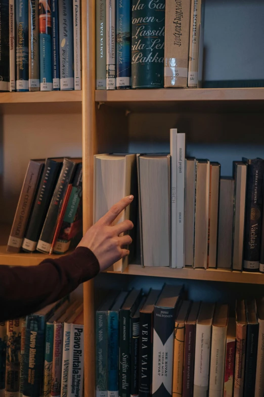 a man that is standing in front of a book shelf, hands reaching for her, reddit post, mid shot, low quality photo