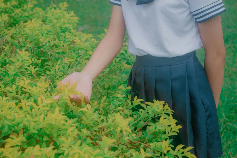 a girl in a dress and blue hat is picking flowers