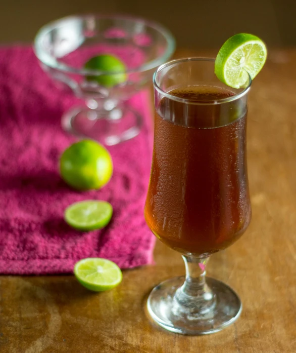 a glass filled with a drink sitting on top of a table, lime, brown, thumbnail, recipe