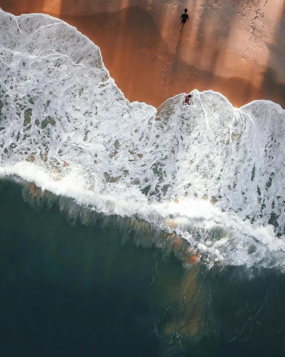 a group of people riding surfboards on top of a sandy beach, pexels contest winner, bird's eye, thumbnail, ocean spray, /r/earthporn