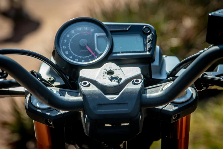 a close up of the handle bar of a motorcycle, by Daniel Seghers, lcd screen, orange details, off - road, sunny environment