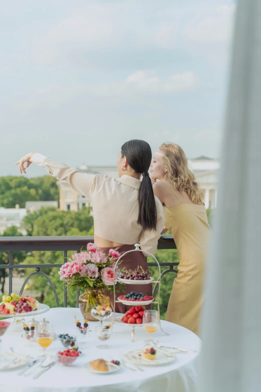 two women looking out over the city from their balcony