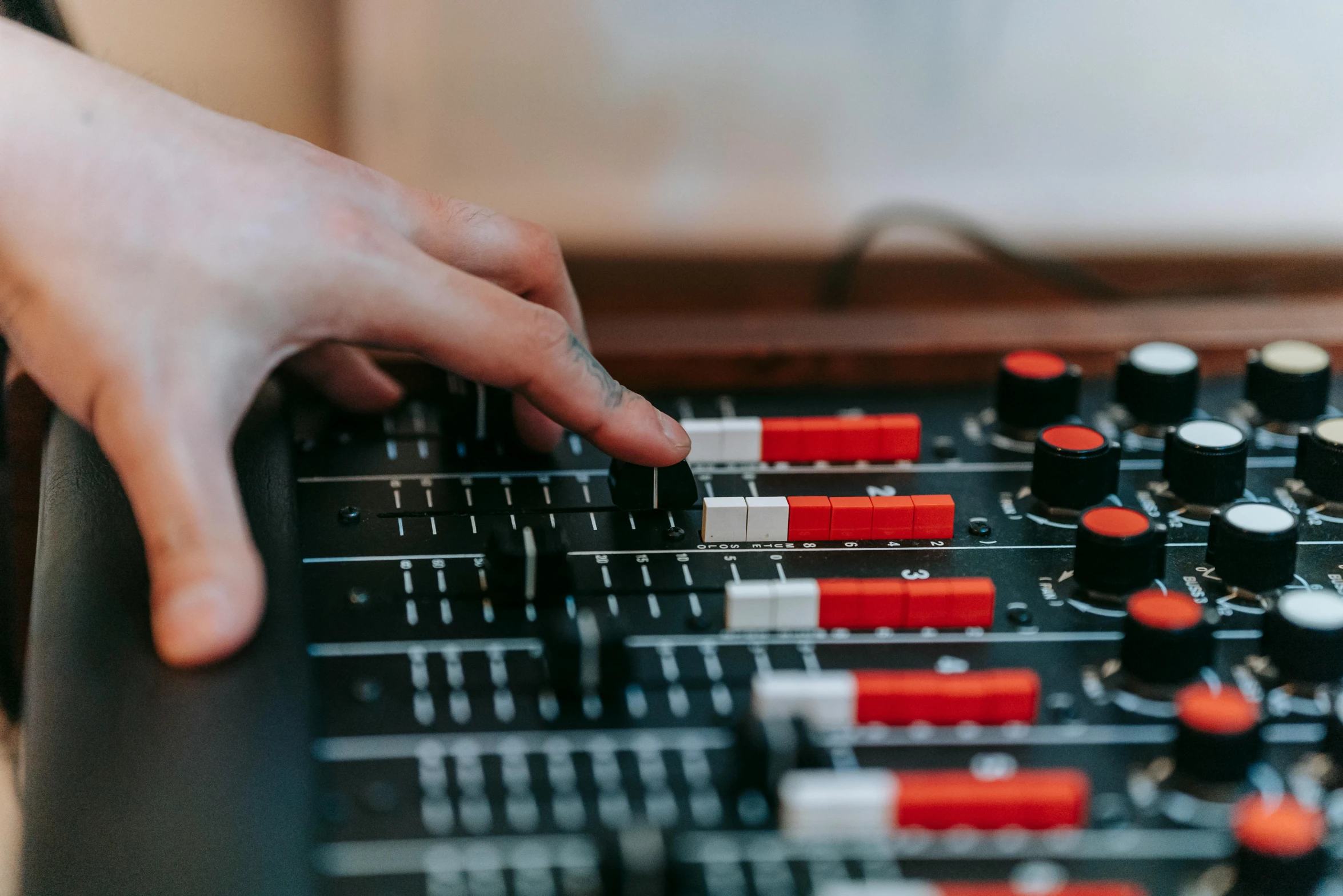 a close up of a person's hand on a mixing board, trending on pexels, interactive art, slightly red, radios, avatar image, amanda lilleston