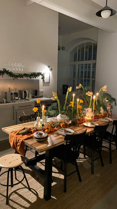 a long wooden table surrounded by flower arrangements