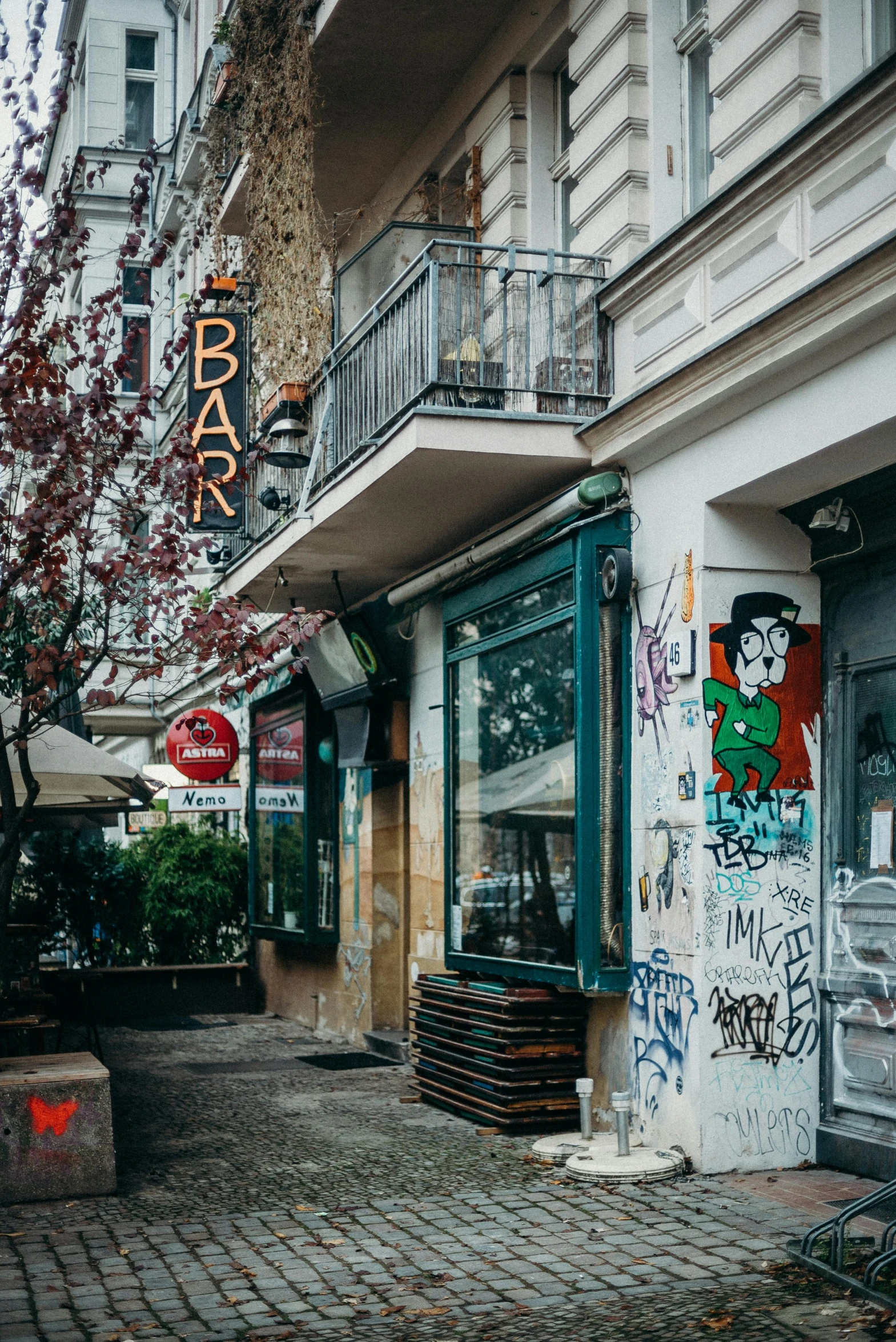 a red fire hydrant sitting on the side of a street, a photo, by Micha Klein, pexels contest winner, graffiti, inside a bar, cronenberg bookshop, a busy arcade, greek