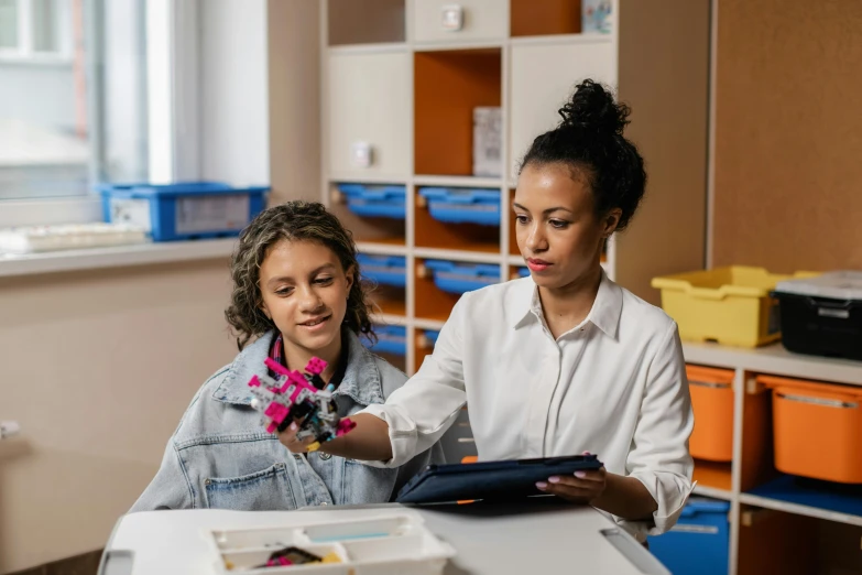 a woman and a young girl sitting at a table, pexels contest winner, danube school, holding a clipboard, avatar image, colour photo, inspect in inventory image