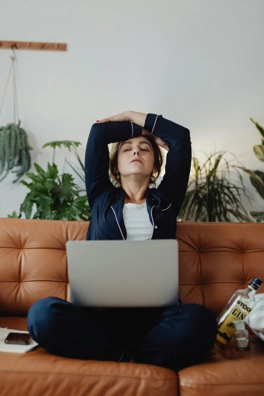 a woman sitting on a couch using a laptop, pexels, renaissance, tired and drunk, stretch, tall forehead, over it's head