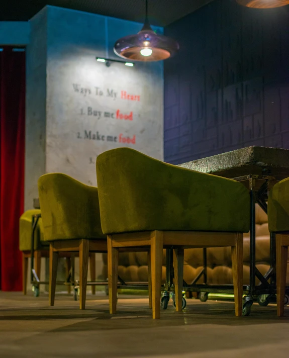 some chairs and tables with red curtains behind them