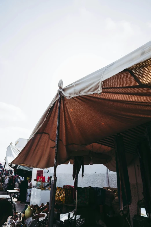 a group of people standing outside of a tent, by Daniel Lieske, trending on unsplash, renaissance, inside an arabian market bazaar, awnings, high textured, close up shot from the side