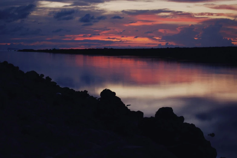 clouds that are sitting in the sky above a body of water