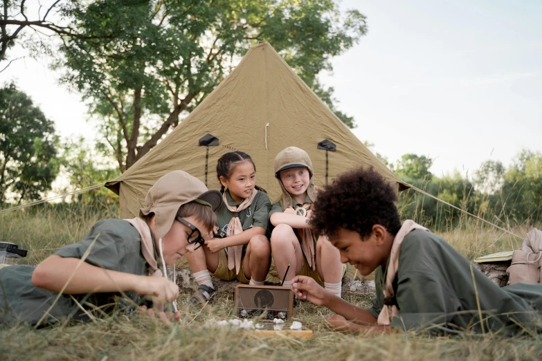 a group of children sitting on the ground in front of a tent, pexels contest winner, renaissance, boy scout troop, manuka, khakis, game ready