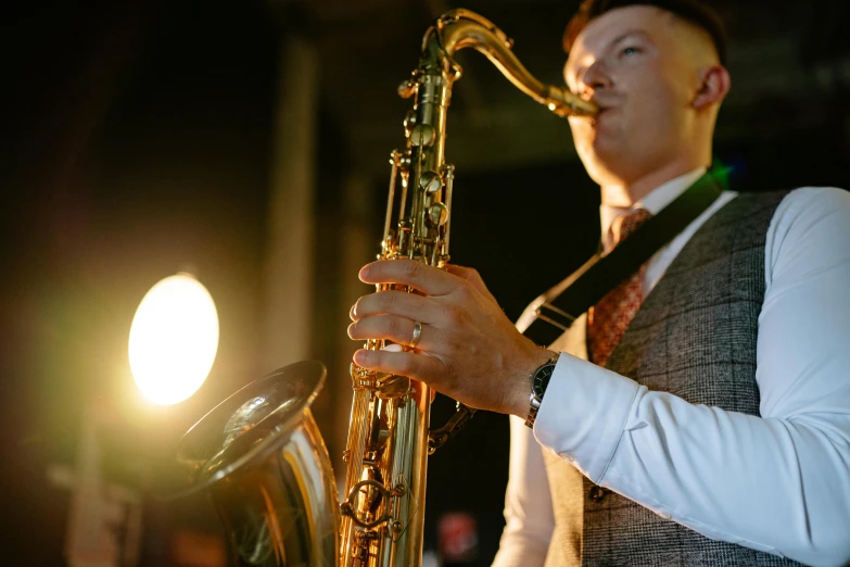 a man playing the saxophone at night in the dark