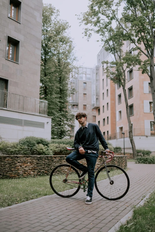 a man riding on the back of a bike down a sidewalk