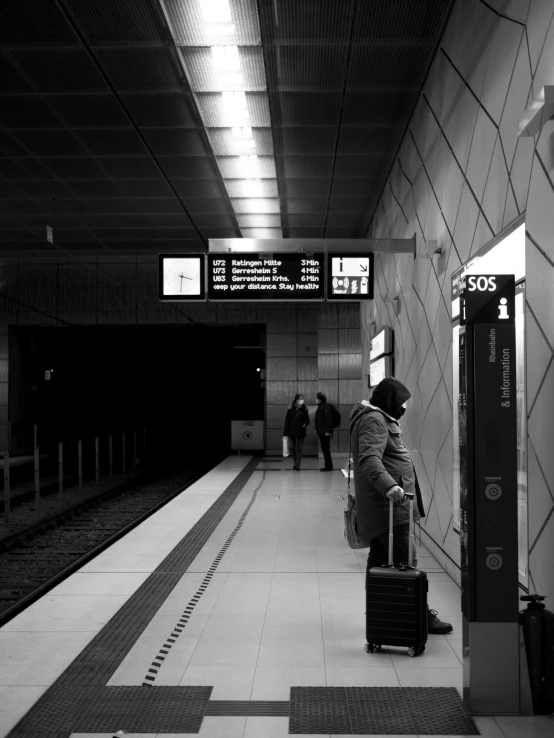 a black and white photo of people waiting at a train station, a black and white photo, by Mathias Kollros, man standing, luggage, in empty!!!! legnica, praying