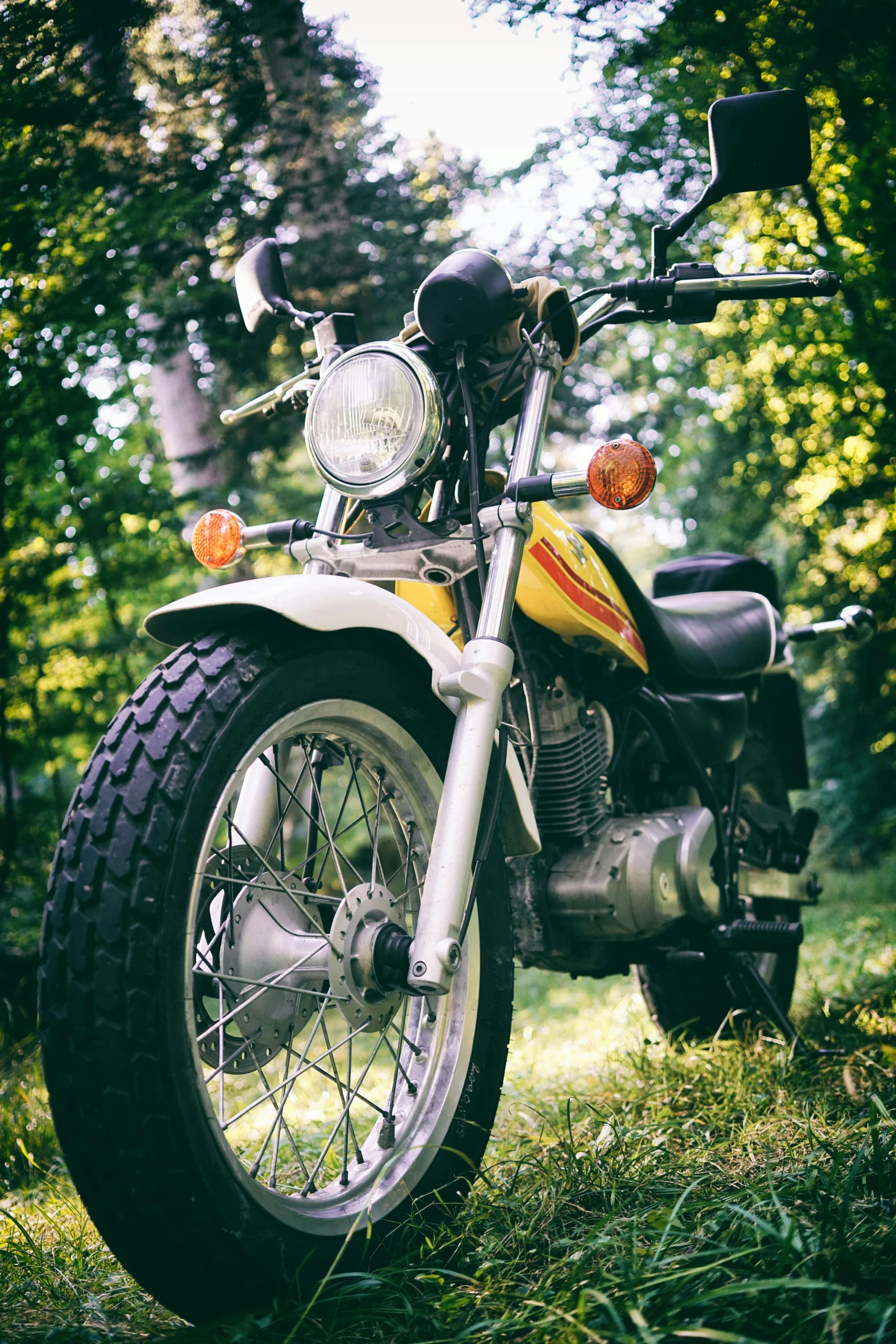 a motorcycle that is parked in the grass, inspired by Hiroshi Honda, unsplash, photorealism, 2 5 6 x 2 5 6 pixels, 1972 soviet, front closeup, colour photo