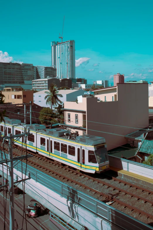 a train traveling through a city next to tall buildings, a colorized photo, manila, slide show, square, lofi aesthetic