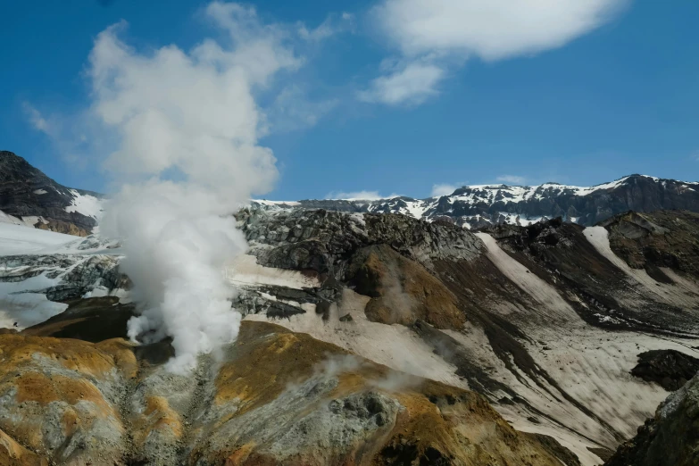 a view of a volcano with steam rising from it