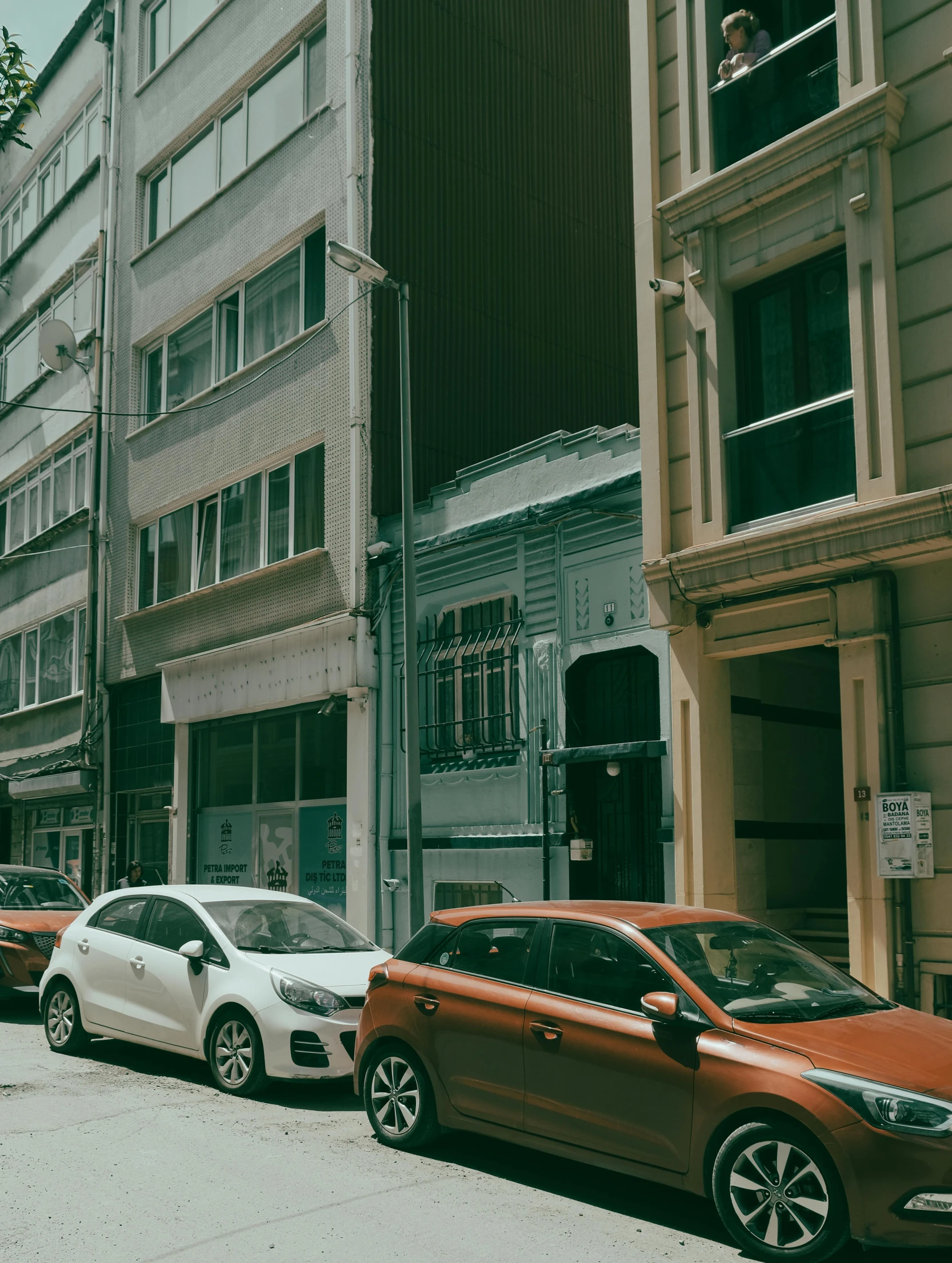 a row of parked cars on a city street, inspired by Elsa Bleda, pexels contest winner, hyperrealism, neo classical architecture, fallout style istanbul, low quality photo, vintage color photo