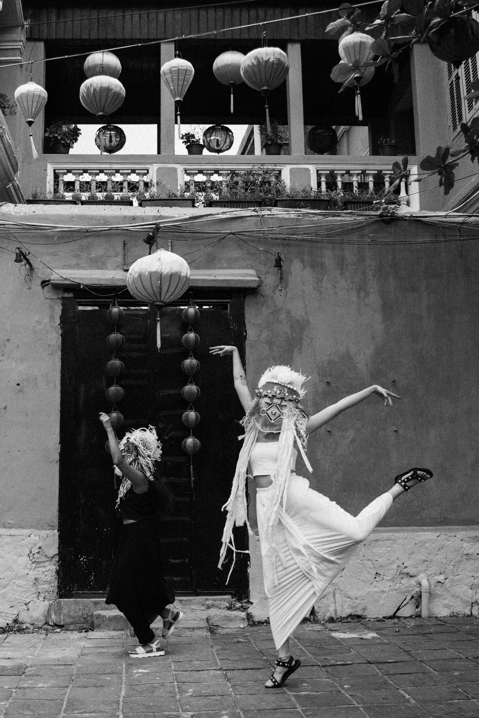 a black and white photo of two women dancing in front of a building, unsplash, kitsch movement, white hair floating in air, in style of lam manh, posing for camera, white witch